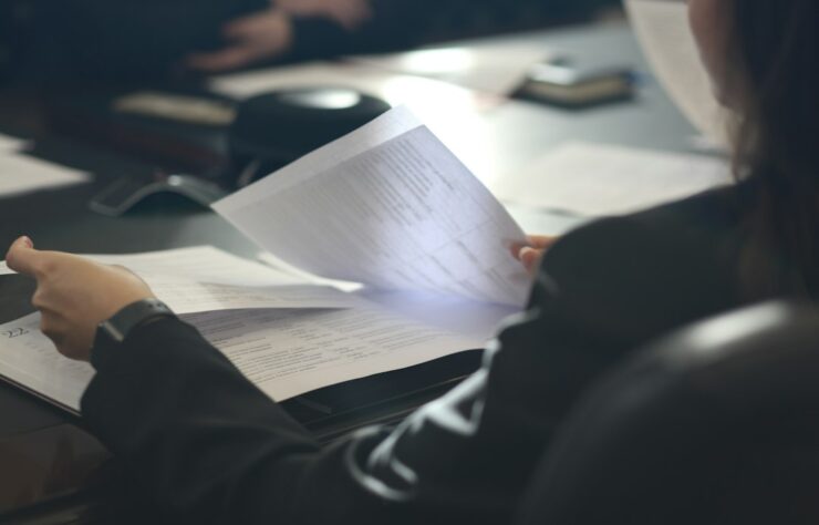 Professional reviewing documents — Anastassia Anufrieva / Unsplash Professional reviewing employment documents, illustrating LMIA processing timelines