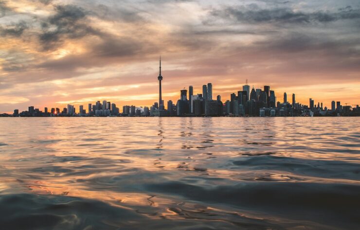 Toronto Ontario skyline — photo by Berkay Gumustekin / Unsplash Toronto skyline viewed across Lake Ontario, illustrating Ontario immigration pathways